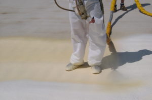 spray foam installer putting foam on flat room