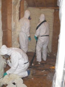 Workers using supplied breathing air while installing spray foam.